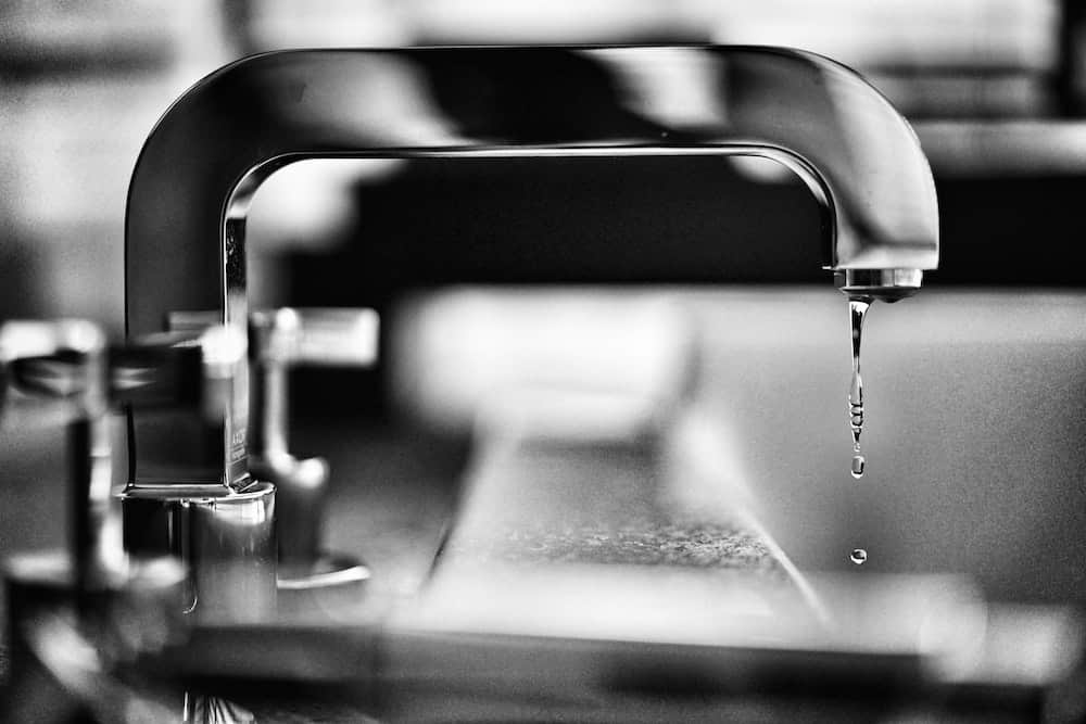 A grayscale photo of a faucet.
